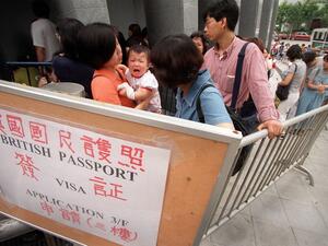 This file photo taken on June 20, 1997 shows people queueing outside the British Council in Hong Kong in hopes of applying for a British National (Overseas) passport, or "BNO", before the handover to China on June 30, 1997 over anxiety about the city's future. A new visa scheme offering millions of Hong Kongers a pathway to British citizenship will go live later on January 31, 2021 as the city's former colonial master opens its doors to those wanting to escape China's crackdown on dissent. STEPHEN SHAVER / 