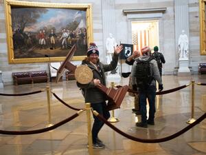 A pro-Trump protester carries the lectern of U.S. Speaker of the House Nancy Pelosi through the Roturnda of the U.S. Capitol Building after a pro-Trump mob stormed the building on January 06, 2021 in Washington, DC. (AFP/File)
