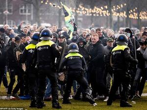 Hundreds of protestors not wearing face masks clash with Dutch riot police at an illegal protest against the Netherlands' new lockdown measures in Museumplein today. (AFP)