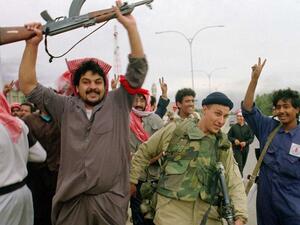Kuwaiti resistance fighters celebrate with a member of the US Marine Special forces on February 26, 1991, after the Marines entered the small town of Sabahiah, 9 miles from the capital of Kuwait City. (AFP File Photo)