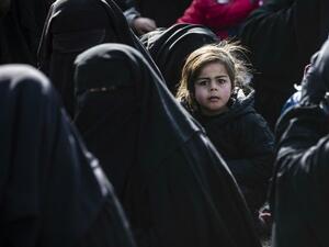 Women lead children ahead of departure during the release of another group of Syrian families from the Kurdish-run al-Hol camp which holds suspected relatives of Islamic State (IS) group fighters, in Hasakeh governorate in northeastern Syria, on January 28, 2021. Delil SOULEIMAN / AFP
