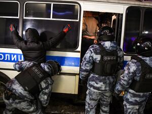 A riot police officer searches a detained man during a protest against a court ruling ordered Russian opposition leader Alexei Navalny jailed for nearly three years, in downtown Moscow early on February 3, 2021. NATALIA KOLESNIKOVA / AFP