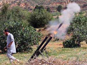 In this file photo taken on April 19, 2020, a fighter with Libya's UN-recognised Government of National Accord (GNA) fires rockets from a position near the town of Garabulli toward the city of Tarhuna, southwest of the capital Tripoli, held by the forces of the Libyan strongman Khalifa Haftar. Mahmud TURKIA / AFP