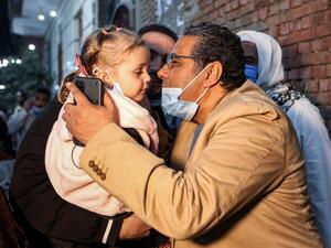 Mahmoud Hussein (R), an Egyptian national and senior journalist for Qatar-based Al Jazeera Arabic, kisses a child upon his arrival at his family home in the Giza village of Zawyet Abu Musallam, about 30 kilometres south of Egypt's capital Cairo on February 6, 2021 upon his release from detention. Egypt has freed the journalist for Qatar's Al Jazeera after four years in jail without trial following the end last month of a rift between the two Arab states. Mahmoud Hussein, an Egyptian national who had been im