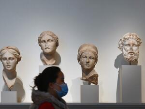 A visitor wearing a facemask walks past stone sculptures at The Metropolitan Museum of Art, 'The Met' in New York City on February 9, 2021. Angela Weiss / AFP