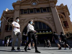 People cross a street in Melbourne on February 12, 2021, after authorities ordered a five-day state-wide lockdown starting at midnight local time to stamp out a new coronavirus outbreak. Con Chronis / AFP