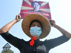 A protester holds up a sign calling for the release of detained Myanmar civilian leader Aung San Suu Kyi during a demonstration against the military coup in Naypyidaw on February 16, 2021. STR / AFP