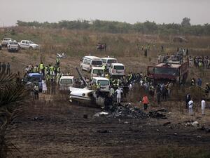 Caregivers work at the scene of an accident involving a Nigerian military aircraft which crashed killing seven occupants on board at the Airport runway near Nigeria's capital Abuja, on February 21, 2021. A Nigerian military aircraft Beechraft KingAir B350 has crashed killing seven personnel on board while returning to the Abuja Airport after reporting engine failure. KOLA SULAIMON / AFP
