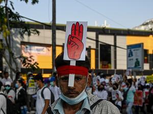 A protesters wears a sign with the three finger salute during a demonstration against the military coup in Yangon on February 22, 2021. Ye Aung THU / AFP