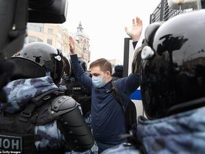 A protester holds up his arms while surrounded by riot police who detained him during the crackdown on anti-Putin rallies. (AFP/File)
