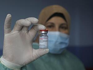A Palestinian health worker holds vial of Covid-19 vaccine at Palestine Red Crescent hospital in West Bank city of Nablus, on 4 February (AFP/File photo)
