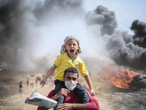 Palestinian father and son protesting at the borders between Gaza strip and Israel  (Shutterstock)	