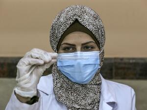 A Palestinian nurse checks the vaccine 