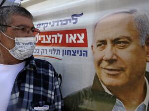 An Israeli wearing a mask with the Likud party logo