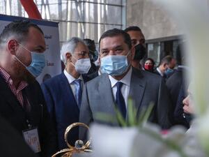 Libya's  interim PM Abdul Hamid Dbeibah (C) arrives to deliver a speech at a conference on COVID-19 in Tripoli