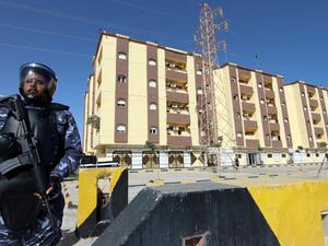 Libyan security forces stand guard outside the entrance to the conference center 