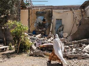 امرأة تسير أمام منزل مدمر في مدينة ووكرو في شمال ميكيلي في إقليم تيغراي