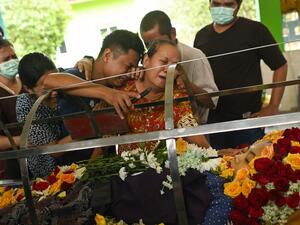 Relatives cry at the body of Su Su Kyi