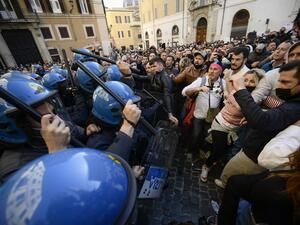 Anti-riot policemen (L) use batons against protesters during skirmishes in a demonstration 