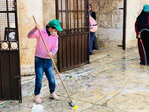 طفلة فلسطينية تنظف باحات المسجد الأقصى