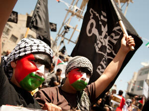 Faces painted with the Palestinian flag, boys march in Ramallah on Nakba Day
