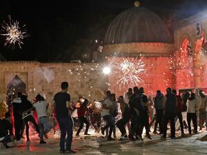 Stun grenades burst in the air amid clashes between Palestinian protesters and Israeli security forces at the al-Aqsa mosque compound in Jerusalem