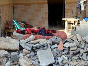 A Palestinian boy sleeps in the ruins of his family house that was destroyed in Israeli air strikes during the most recent Israeli-Palestinian fighting, in Gaza City