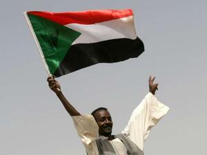 A man holds a Sudanese flag 