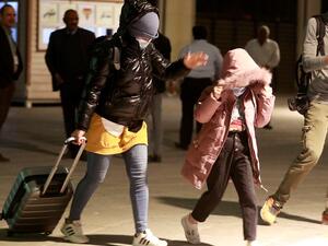 Iraqis covers her face as she arrives at the airport in Baghdad after being flown home from the Belarusian capital Minsk, on November 18, 2021. 