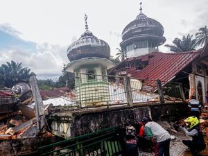 Villagers try to communicate with the victims under the rubble of a mosque, in West Pasaman, on February 25, 2022, after a magnitude 6.2 earthquake hit the area and damaged hundreds of houses and public facilities. (Photo by Ardhy FERNANDO / AFP) strong earthquake