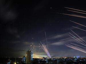 In the background the Israeli Iron Dome missile defence system (L) intercepts rockets (R) fired by the Hamas movement towards southern Israel from Beit Lahia in the northern Gaza Strip. AFP / ANAS BABA Iron Dome