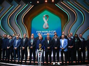 Coaches pose in front of the World Cup trophy during the draw for the 2022 World Cup in Qatar at the Doha Exhibition and Convention Center on April 1, 2022. (Photo by FRANCK FIFE / AFP)