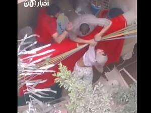 اللقطات تصور رجلا يحاول "تأديب" ابنته من خلال تهديدها بإلقائها من الشرفة.