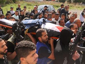 Mourners and masked armed men carry the body of veteran Al Jazeera Palestinian journalist Shireen Abu Aqleh, who was shot dead as she covered a raid on the West Bank's Jenin refugee camp, on May 11, 2022 before it is transferred for burial. (Photo by JAAFAR ASHTIYEH / AFP) veteran Al Jazeera Palestinian journalist Shireen Abu Aqleh