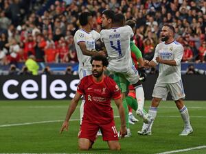 Real Madrid's teammates congratulate Real Madrid's Belgian goalkeeper Thibaut Courtois (rear C) after he saved a shot by Liverpool's Egyptian midfielder Mohamed Salah reacting on the foreground during the UEFA Champions League final football match between Liverpool and Real Madrid at the Stade de France in Saint-Denis, north of Paris, on May 28, 2022. (Photo by Paul ELLIS / AFP)