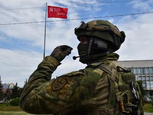 This photo taken on May 20, 2022, shows a Russian serviceman patrolling the street in Kherson, amid the ongoing Russian military action in Ukraine. (Photo by Olga MALTSEVA / AFP) Kherson region