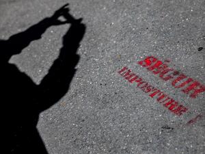 A photo shows an inscription on the ground, reading "Segur (general talks on Health reforms), Imposture", in front of the Tenon hospital in Paris during a gathering of health workers denouncing the deterioration of their working conditions, on May 25, 2022. (Photo by AFP) French health professionals strike against staff shortage