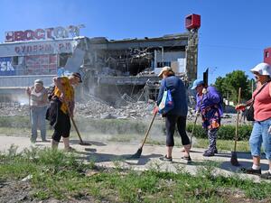 Communal workers clean up the rubble of a supermarket, partially destroyed by a missile attack on the southeastern outskirts of the Ukrainian city of Kharkiv on June 8, 2022 amid the Russian invasion of Ukraine. (Photo by SERGEY BOBOK / AFP) Missile hits shopping center in Ukraine's Kharkiv city