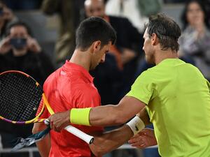 Spain's Rafael Nadal (R) shakes hands with Serbia's Novak Djokovic (L) after winning at the end of their men's singles match on day ten of the Roland-Garros Open tennis tournament at the Court Philippe-Chatrier in Paris early June 1, 2022. (Photo by Anne-Christine POUJOULAT / AFP)