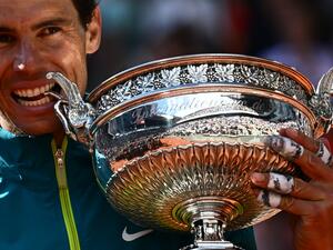 Spain's Rafael Nadal poses with The Musketeers' Cup as he celebrates after victory over Norway's Casper Ruud during their men's singles final match on day fifteen of the Roland-Garros Open tennis tournament at the Court Philippe-Chatrier in Paris on June 5, 2022. (Photo by Anne-Christine POUJOULAT / AFP)
