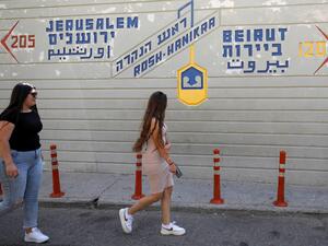 Women walk past the Israeli Rosh Hanikra Crossing, also known as the Ras al-Naqoura Crossing, between Israel and Lebanon on June 6, 2022. (Photo by JALAA MAREY / AFP) natural gas