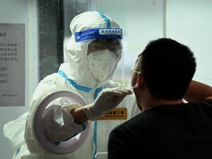 A health worker takes a swab sample from a man to test for the Covid-19 coronavirus in Beijing on June 21, 2022. (Photo by Noel Celis / AFP)