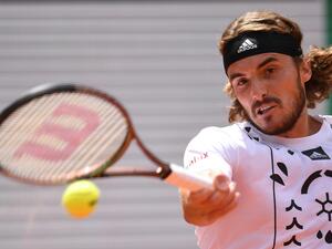 Greece's Stefanos Tsitsipas returns the ball to Denmark's Holger Rune during their men's singles match on day nine of the Roland-Garros Open tennis tournament at the Court Philippe-Chatrier in Paris on May 30, 2022. (Photo by JULIEN DE ROSA / AFP)