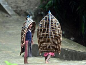 Rohingya refugee children gesture as they make their way during monsoon rainfall in Kutupalong refugee camp in Ukhia on August 10, 2022. (Photo by Munir uz Zaman / AFP) Myanmar military