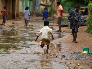 A boy runs in flood water following heavy rain in Sudan's capital Khartoum, on August 13, 2022. (Photo by ASHRAF SHAZLY / AFP) Sudan