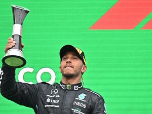 Mercedes' British driver Lewis Hamilton celebrates with the trophy on the podium after the Formula One Hungarian Grand Prix at the Hungaroring in Mogyorod near Budapest, Hungary, on July 31, 2022. (Photo by Attila KISBENEDEK / AFP)
