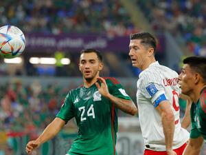 Mexico's midfielder #24 Luis Chavez (L) fights for the ball with Poland's forward #09 Robert Lewandowski during the Qatar 2022 World Cup Group C football match between Mexico and Poland at Stadium 974 in Doha on November 22, 2022. (Photo by Odd ANDERSEN / AFP)
