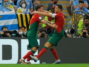 Portugal's forward #07 Cristiano Ronaldo (R) celebrates with Portugal's midfielder #08 Bruno Fernandes after he scored his team's first goal during the Qatar 2022 World Cup Group H football match between Portugal and Uruguay at the Lusail Stadium in Lusail, north of Doha on November 28, 2022. (Photo by Odd ANDERSEN / AFP)