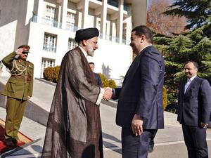 Raisi (L) receives Sudani 