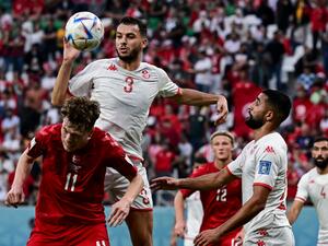 Denmark's midfielder #11 Andreas Skov Olsen (L) and Tunisia's defender #03 Montassar Talbi fight for the ball during the Qatar 2022 World Cup Group D football match between Denmark and Tunisia at the Education City Stadium in Al-Rayyan, west of Doha on November 22, 2022. (Photo by Miguel MEDINA / AFP)